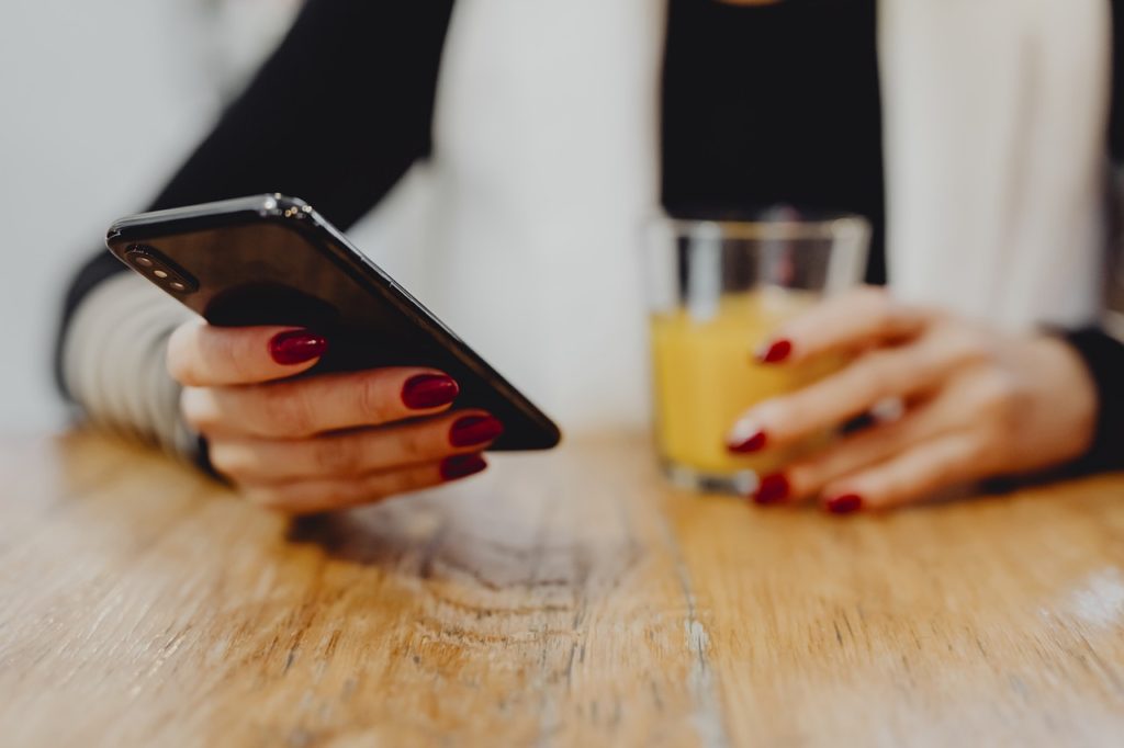 Donna tiene smartphone in mano
