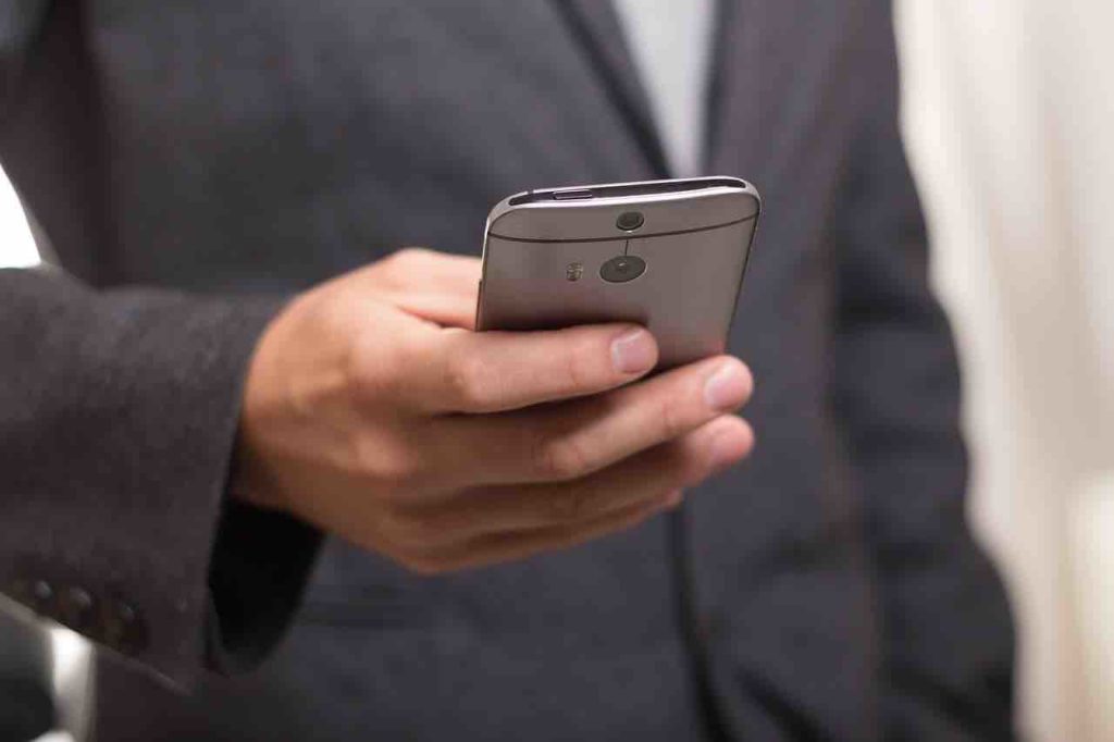 Uomo tiene smartphone in mano