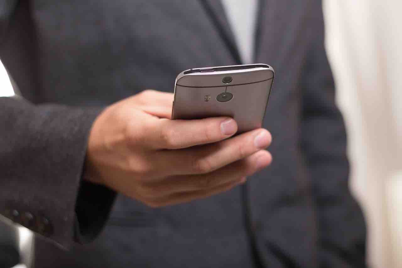 Uomo tiene smartphone in mano